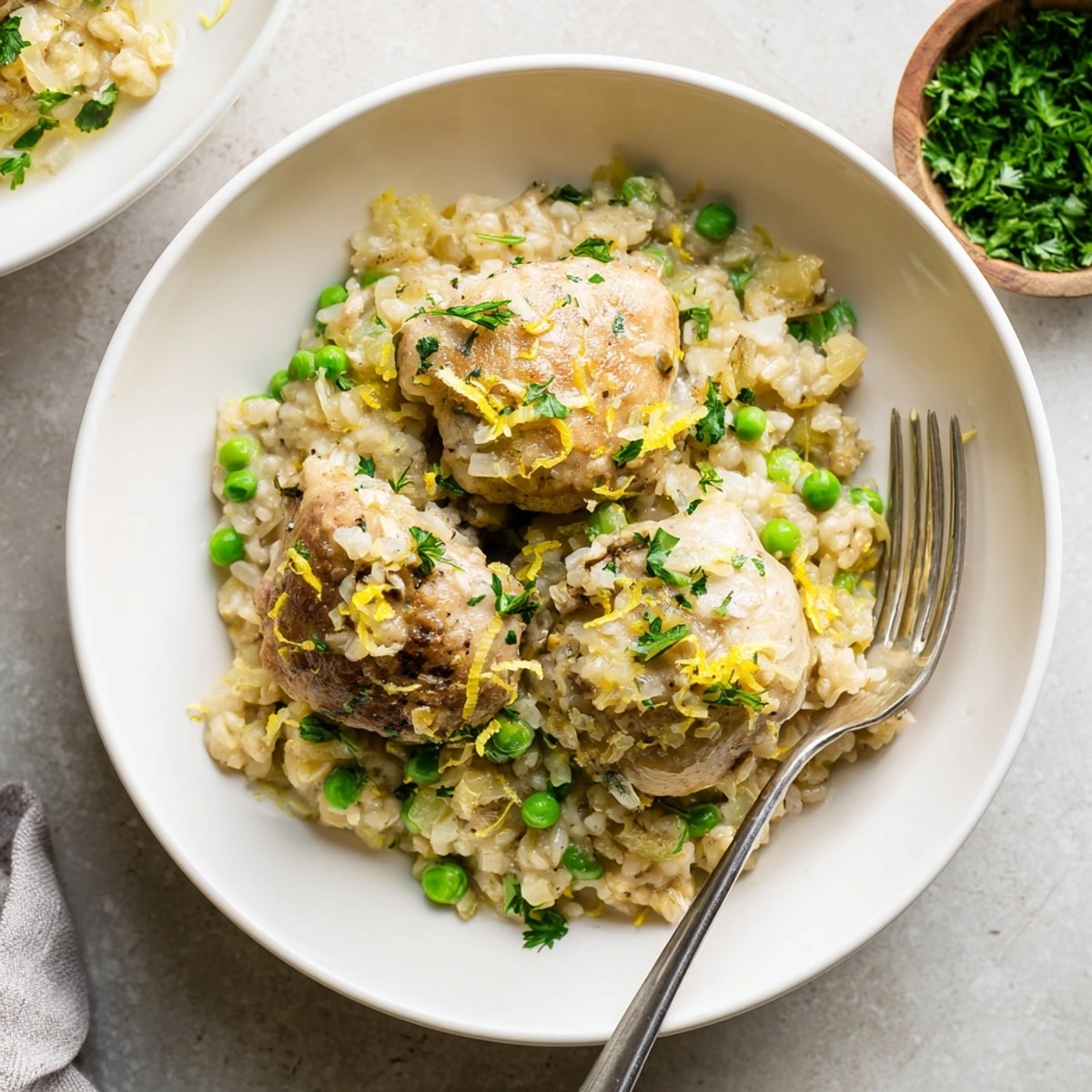 Steaming bowl of One-Pot Creamy Lemon Chicken and Rice with tender chicken and vibrant peas.