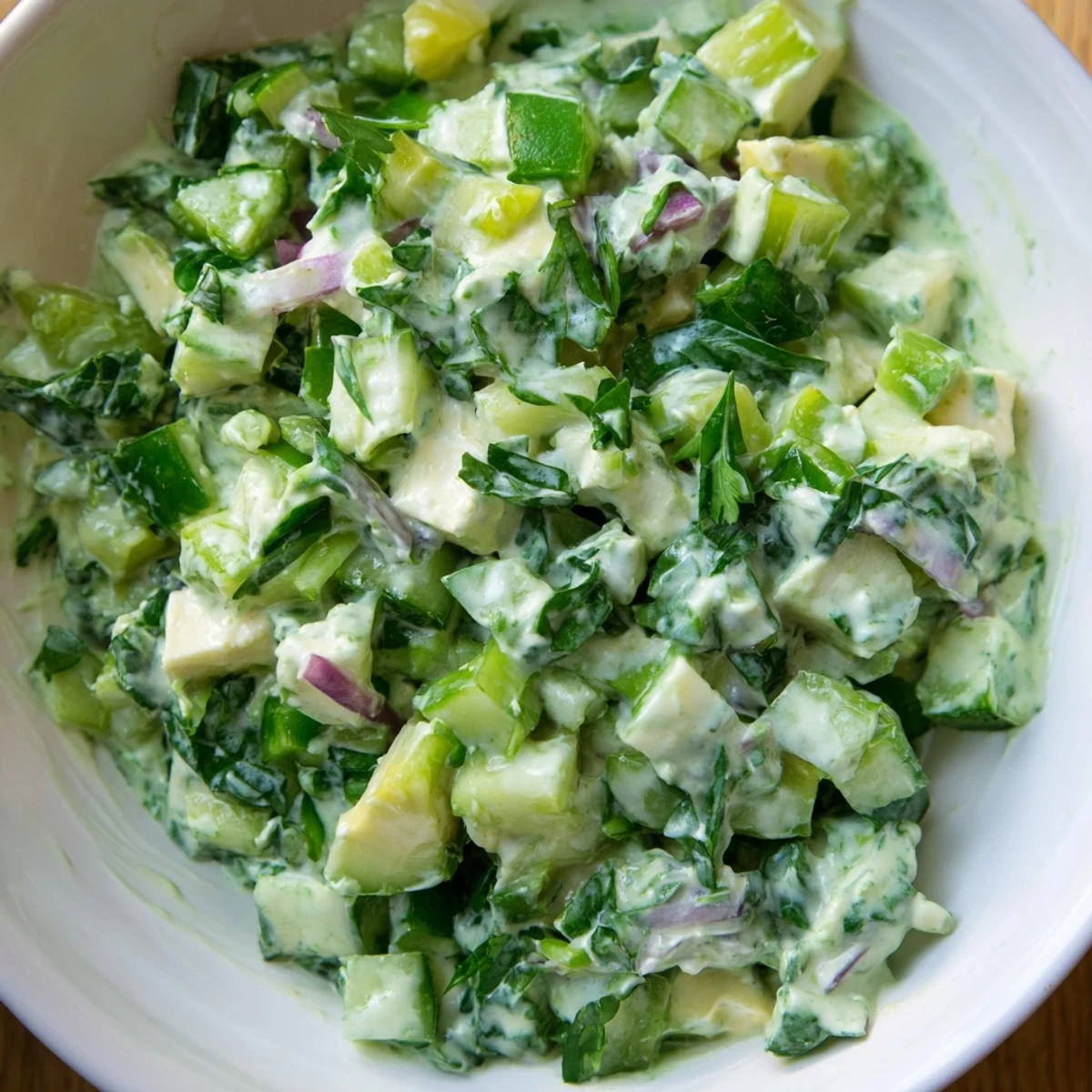 A vibrant bowl of fresh Green Goddess Cabbage Dip, ready to scoop, featuring bright green hues.