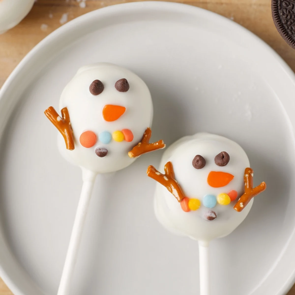 White chocolate-covered Oreo Snowman Cake Pops, adorable and festive, ready for a winter treat.