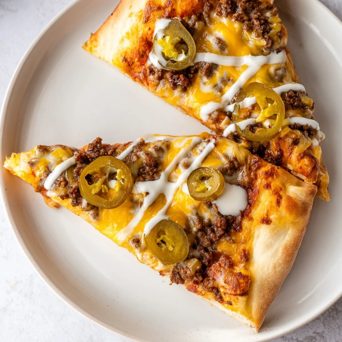 Ground Beef Taco Pizza: A delicious close-up showcases the melted cheese and taco-seasoned ground beef.