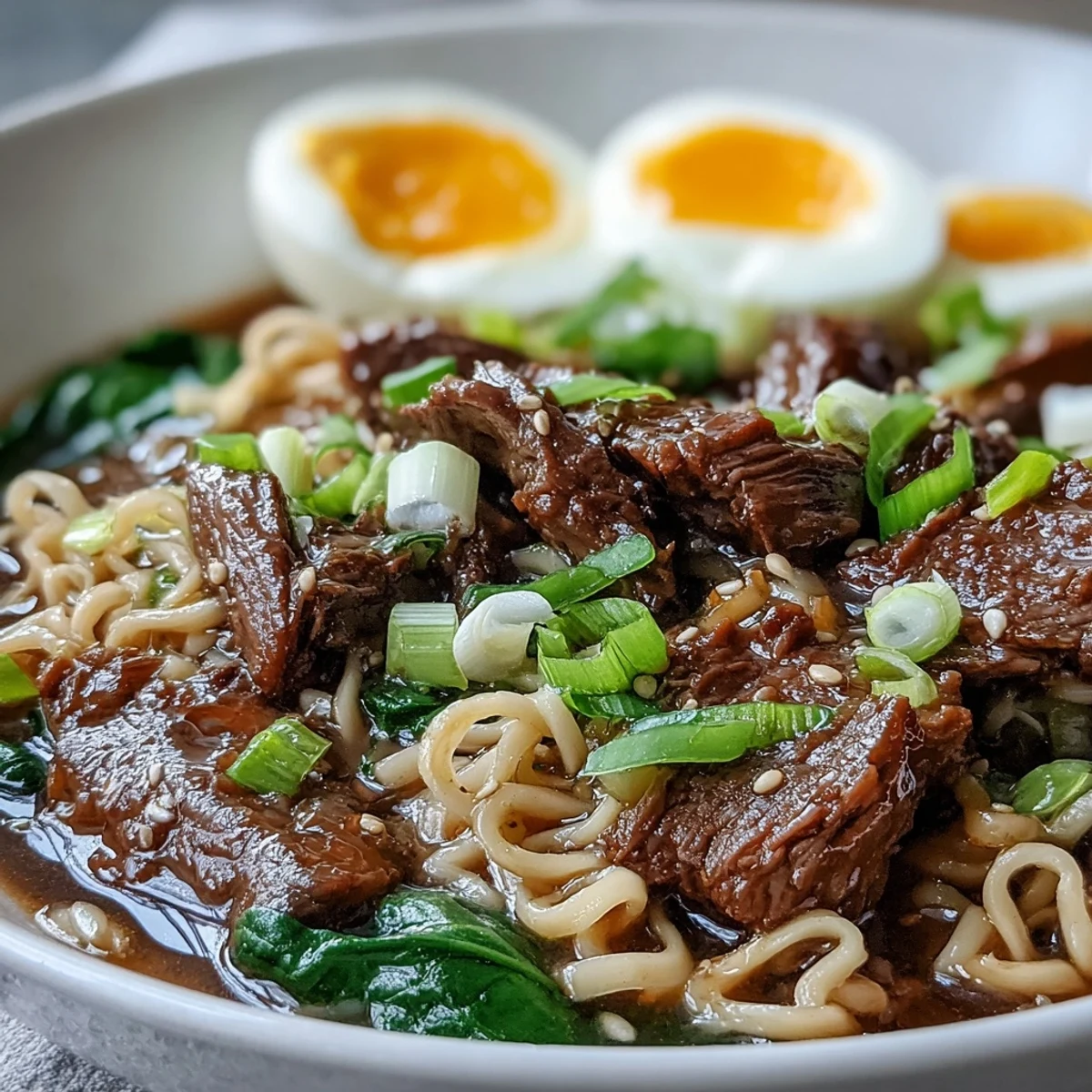 Steaming Slow Cooker Beef Ramen Noodles topped with soft-boiled eggs and green onions for a cozy meal.