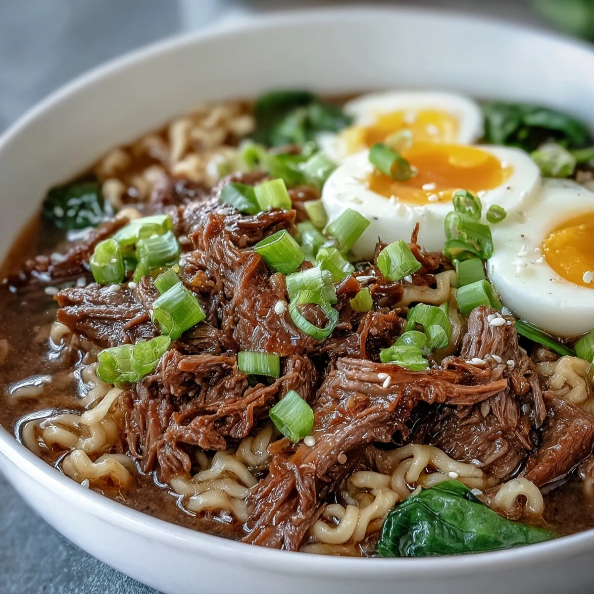 Fork-tender Slow Cooker Beef Ramen Noodles served with fresh ramen noodles, garnishes, and chili oil drizzle.