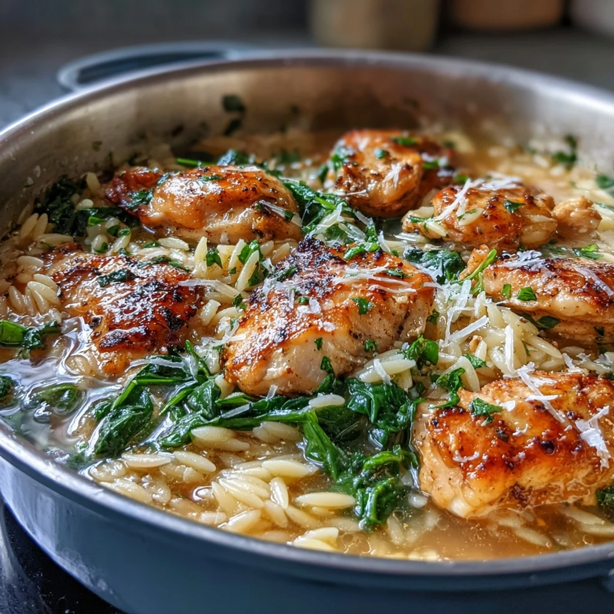 Golden-seared chicken simmers with orzo, garlic, and lemon in a single pot, finished with vibrant spinach and herbs for a cozy dinner.  