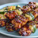 Grilled chicken skewers with honey-lime marinade, zucchini, and pineapple, charred to juicy perfection for a vibrant summer meal.