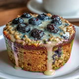 Golden baked oatmeal cups filled with fresh blueberries and zesty lemon, offering a delicious grab-and-go morning meal.
