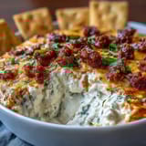 Festive Cinco de Mayo loaded queso dip features melted cheddar and Monterey Jack cheese topped with savory chorizo and fresh toppings.