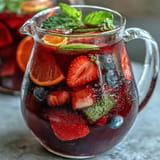Refreshing glass of iced hibiscus berry tea, bursting with fresh fruit flavors.