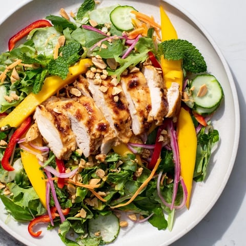Juicy Thai Mango Chicken Salad with fresh cilantro and vibrant red bell pepper slices.