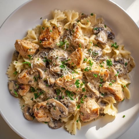 Creamy mushroom chicken pasta, golden chicken pieces mingling with rich sauce and perfectly cooked pasta.