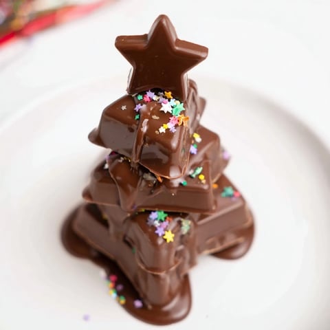 Festive Chocolate Kinder Christmas Trees, drizzled with glossy chocolate and topped with star sprinkles.