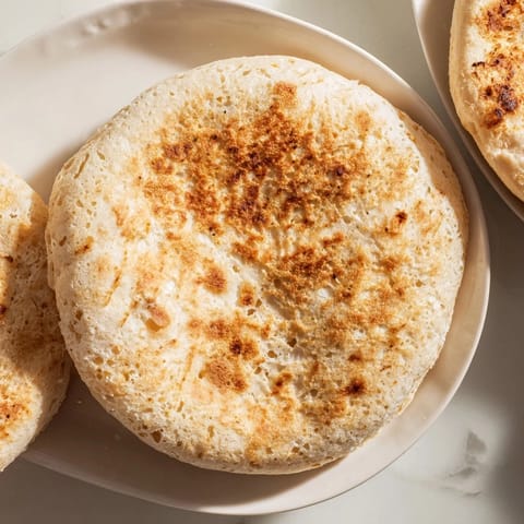 Freshly cooked Three-Ingredient Easy Flatbreads, visibly puffed up, waiting to be served with hummus.