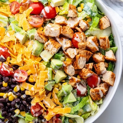 Fresh, colorful ingredients like diced avocado and black beans highlight this easy Chicken Taco Chopped Salad.  