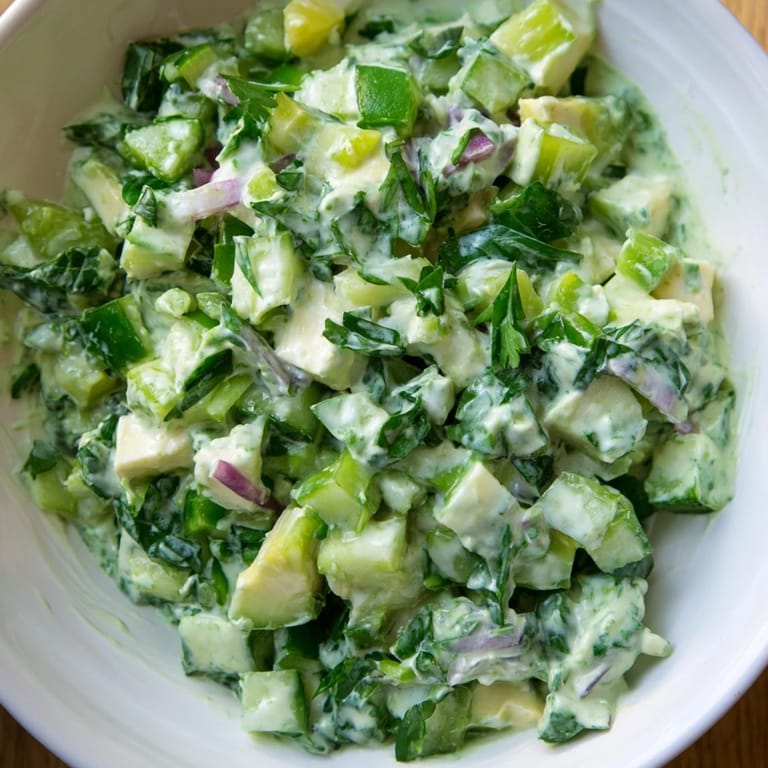 A vibrant bowl of fresh Green Goddess Cabbage Dip, ready to scoop, featuring bright green hues.