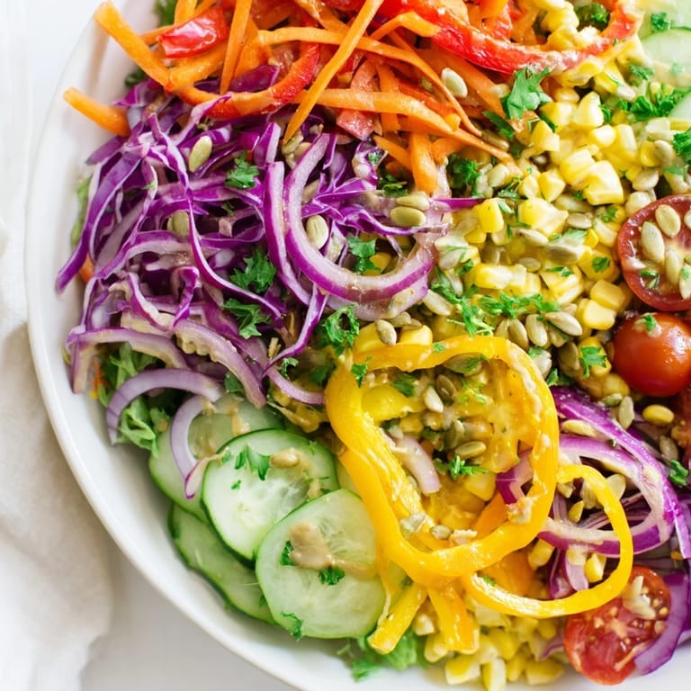Vibrant rainbow salad, easily tossed with a tangy tahini dressing for a light, delicious meal.