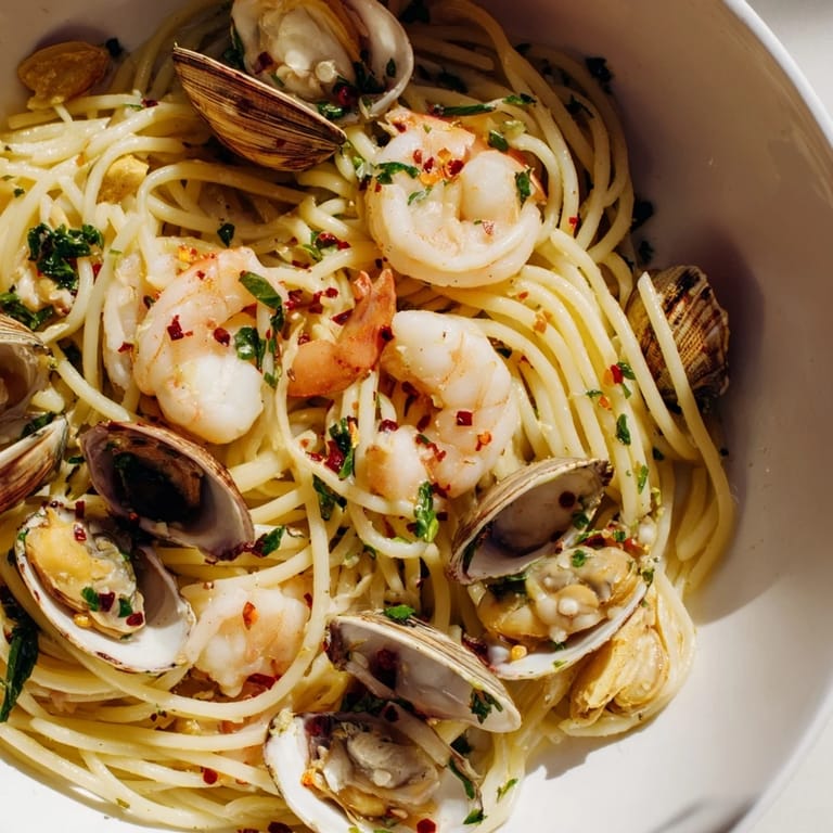 Close-up of a flavorful Seafood Pasta Aglio e Olio, glistening with olive oil and perfectly cooked seafood.