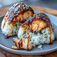 Grilled salmon onigiri with tender rice and savory fish filling, perfect for a light meal or snack.  